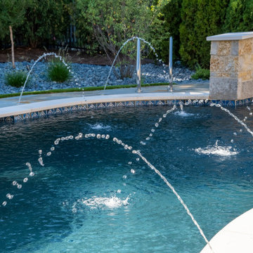 Naperville, IL freeform swimming pool with hot tub, large sunshelf, glass tile