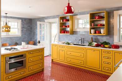 Contemporary eat-in kitchen in Boston with an undermount sink, yellow cabinets, blue splashback, stainless steel appliances, with island and flat-panel cabinets.