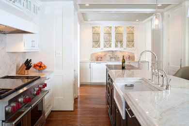 Inspiration for a mid-sized transitional l-shaped light wood floor and brown floor kitchen remodel in DC Metro with a farmhouse sink, raised-panel cabinets, black cabinets, marble countertops, stone slab backsplash, paneled appliances, white backsplash and an island