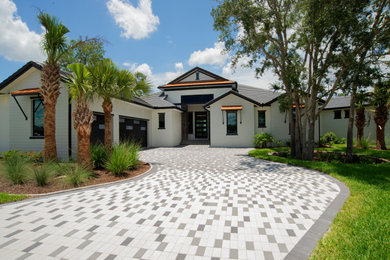 Large trendy one-story stucco and clapboard house exterior photo in Orlando with a hip roof and a mixed material roof
