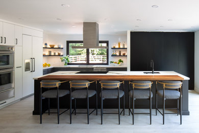 Example of a large trendy l-shaped laminate floor and gray floor eat-in kitchen design in San Diego with flat-panel cabinets, quartz countertops, an undermount sink, black cabinets, white backsplash, white appliances, an island and white countertops