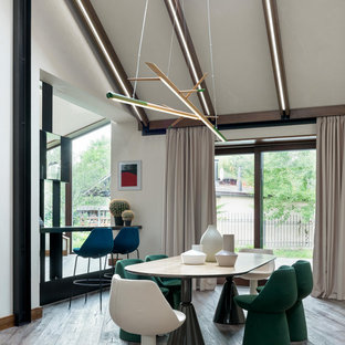Idées déco pour une salle à manger contemporaine avec un mur blanc, aucune cheminée, un sol marron et un plafond voûté.