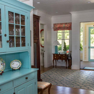 This is an example of a mid-sized eclectic foyer in Grand Rapids with white walls, medium hardwood floors, a single front door, a white front door and brown floor.