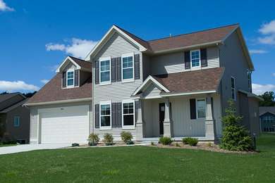 This is an example of a large two-storey beige exterior in Grand Rapids with vinyl siding.