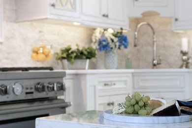 Example of a large classic l-shaped ceramic tile and beige floor open concept kitchen design in New York with an undermount sink, beaded inset cabinets, white cabinets, marble countertops, white backsplash, stone tile backsplash, stainless steel appliances and an island