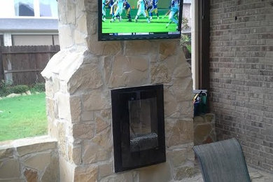 Inspiration for a large modern back patio in Houston with a fireplace.