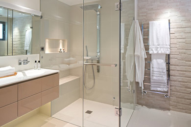 Corner shower - mid-sized contemporary master beige tile and ceramic tile ceramic tile corner shower idea in Chicago with flat-panel cabinets, brown cabinets, beige walls, an integrated sink and solid surface countertops