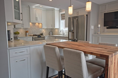 Inspiration for a mid-sized contemporary l-shaped porcelain tile open concept kitchen remodel in Ottawa with an undermount sink, shaker cabinets, white cabinets, quartz countertops, white backsplash, mosaic tile backsplash, stainless steel appliances and a peninsula