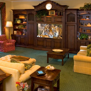 This is an example of a classic home cinema in Los Angeles with a built-in media unit, carpet and green floors.