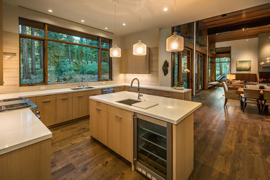 Huge mountain style u-shaped medium tone wood floor eat-in kitchen photo in Sacramento with beige backsplash, stainless steel appliances and an island