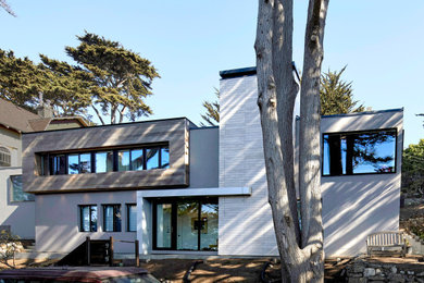 Example of a mid-sized minimalist gray two-story mixed siding house exterior design in San Francisco with a hip roof, a metal roof and a gray roof
