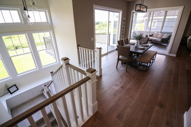 Example of a mid-sized eclectic medium tone wood floor and brown floor great room design in Other with beige walls, a two-sided fireplace and a stone fireplace