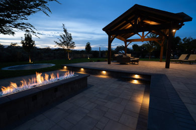 Example of a mid-sized arts and crafts backyard concrete paver patio design in Salt Lake City with a fire pit and a gazebo