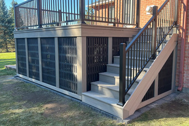 Large backyard ground level metal railing deck skirting photo in Ottawa