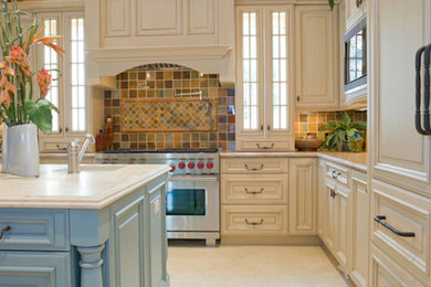 Inspiration for a mid-sized traditional l-shaped kitchen in Las Vegas with an undermount sink, raised-panel cabinets, beige cabinets, marble benchtops, multi-coloured splashback, ceramic splashback, stainless steel appliances, porcelain floors and with island.
