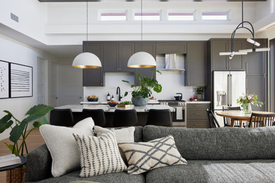 Example of a transitional open concept light wood floor, beige floor and exposed beam living room design in Los Angeles with white walls, a standard fireplace and a stacked stone fireplace