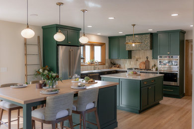 Eat-in kitchen - mid-sized transitional l-shaped light wood floor and brown floor eat-in kitchen idea in Other with an undermount sink, recessed-panel cabinets, green cabinets, quartz countertops, beige backsplash, terra-cotta backsplash, stainless steel appliances, two islands and beige countertops