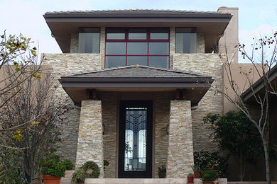 Example of a large trendy beige two-story mixed siding exterior home design in San Diego with a tile roof