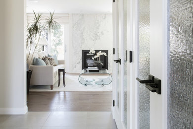 Example of a trendy porcelain tile and gray floor entryway design in Calgary with white walls