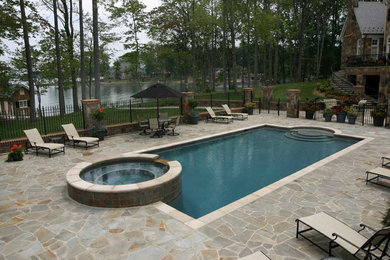 This is an example of a large arts and crafts backyard rectangular pool in Newark with natural stone pavers.