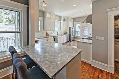 Inspiration for a large craftsman u-shaped medium tone wood floor kitchen pantry remodel in Boise with an undermount sink, recessed-panel cabinets, white cabinets, quartzite countertops, white backsplash, subway tile backsplash and stainless steel appliances