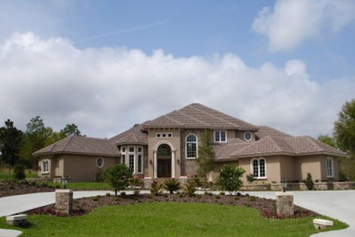 Example of a classic beige three-story brick exterior home design in Tampa