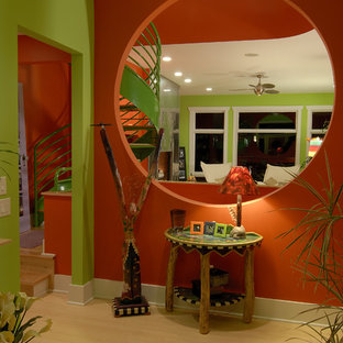 Imagen de distribuidor ecléctico, de tamaño medio, con parades naranjas, suelo de madera clara, puerta simple y puerta de madera clara
