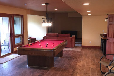 Example of a large transitional walk-out dark wood floor basement design in Denver with beige walls