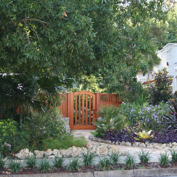 Cypress gate with fencing plus landscaping and hardscape .