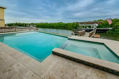 Hot tub - coastal backyard custom-shaped infinity hot tub idea in Tampa with decking
