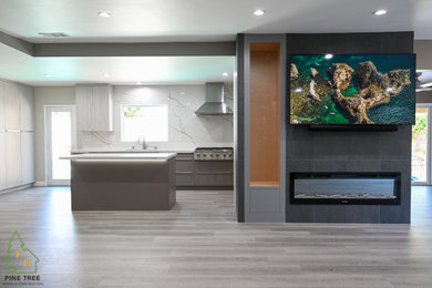 Inspiration for a mid-sized modern galley laminate floor eat-in kitchen remodel in Los Angeles with flat-panel cabinets, white backsplash, stainless steel appliances, an island and white countertops