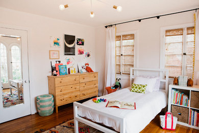 Mid-sized mediterranean gender-neutral kids' bedroom in New York with pink walls and dark hardwood floors for kids 4-10 years old.