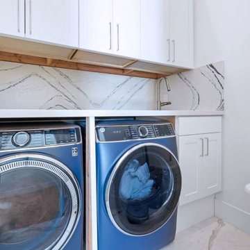 Bright Laundry Room with Marble-Look Backsplash and Built-In Storage
