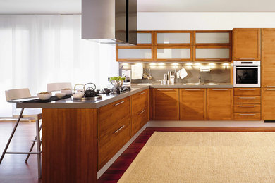 Open concept kitchen - large modern l-shaped medium tone wood floor open concept kitchen idea in Orange County with a double-bowl sink, flat-panel cabinets, medium tone wood cabinets, quartzite countertops, gray backsplash, stainless steel appliances and an island
