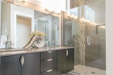 Large trendy master brown tile and ceramic tile beige floor double shower photo in Portland with brown cabinets, an undermount sink, a hinged shower door, flat-panel cabinets, a two-piece toilet, white walls and solid surface countertops