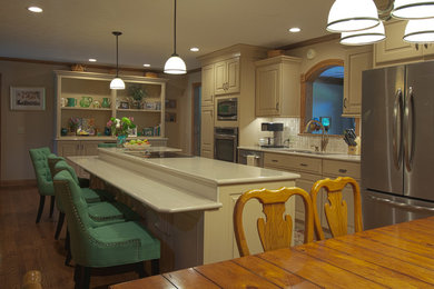 Inspiration for a timeless single-wall medium tone wood floor and brown floor eat-in kitchen remodel in Huntington with an undermount sink, raised-panel cabinets, beige cabinets, quartzite countertops, beige backsplash, porcelain backsplash, stainless steel appliances and an island