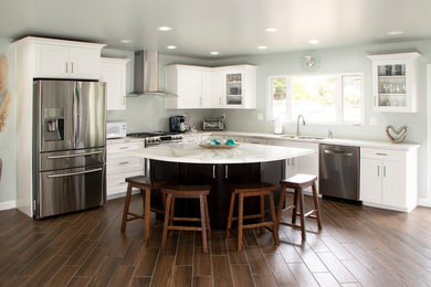 Open concept kitchen - large contemporary l-shaped ceramic tile and brown floor open concept kitchen idea in Other with an undermount sink, flat-panel cabinets, white cabinets, solid surface countertops, stainless steel appliances, an island and white countertops