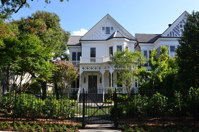 Large traditional white two-story exterior home idea in New Orleans with a shingle roof