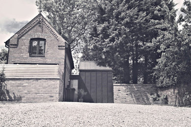 Small trendy black two-story metal exterior home photo in West Midlands with a metal roof