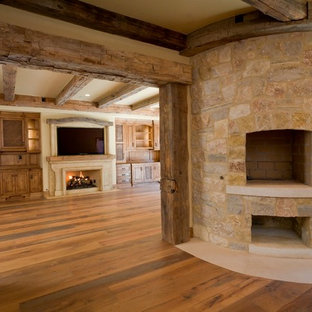 Inspiration for a large traditional basement in San Francisco with beige walls, medium hardwood flooring, a corner fireplace and a stone fireplace surround.