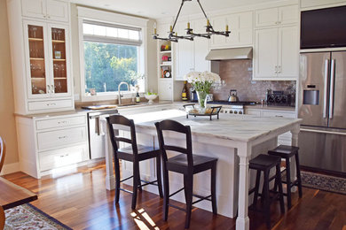 Example of a mid-sized transitional l-shaped medium tone wood floor eat-in kitchen design in Burlington with an undermount sink, beaded inset cabinets, white cabinets, gray backsplash, stainless steel appliances, an island, quartzite countertops and glass tile backsplash