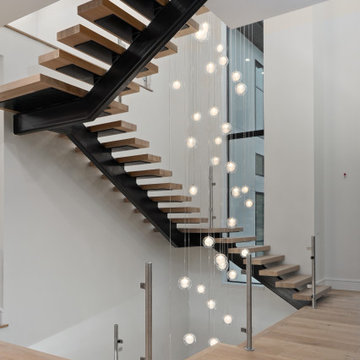 Long 3 story staircase cascading glass globes chandelier. Reflection Twig glass.