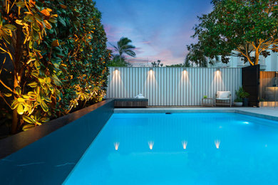 Large contemporary backyard rectangular pool in Sydney with with a pool, with privacy feature and concrete pavers.