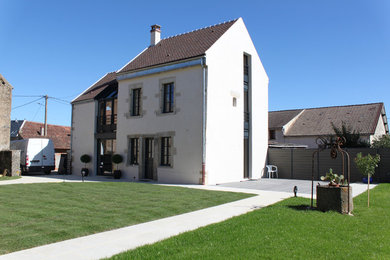 Réalisation d'une façade de maison design de taille moyenne avec un toit à deux pans.