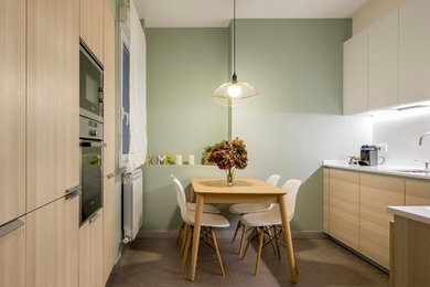 Photo of a contemporary eat-in kitchen in Other with an undermount sink, flat-panel cabinets, light wood cabinets, white splashback, white benchtop, no island and grey floor.
