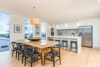 Contemporary open plan dining in Other with white walls, light hardwood floors and brown floor.