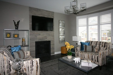 Mid-sized trendy open concept dark wood floor and gray floor family room photo in Ottawa with gray walls, a standard fireplace, a tile fireplace and a wall-mounted tv