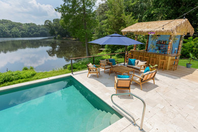 Ejemplo de piscina costera de tamaño medio rectangular en patio trasero con adoquines de piedra natural