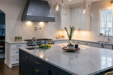 Example of a large u-shaped medium tone wood floor kitchen design in DC Metro with a single-bowl sink, shaker cabinets, quartzite countertops, white backsplash, subway tile backsplash, stainless steel appliances and an island