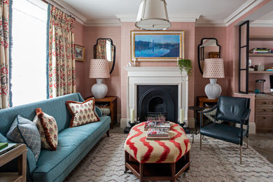ロンドンにあるトランジショナルスタイルのおしゃれなリビング (ピンクの壁、無垢フローリング、標準型暖炉、テレビなし、茶色い床、壁紙) の写真
